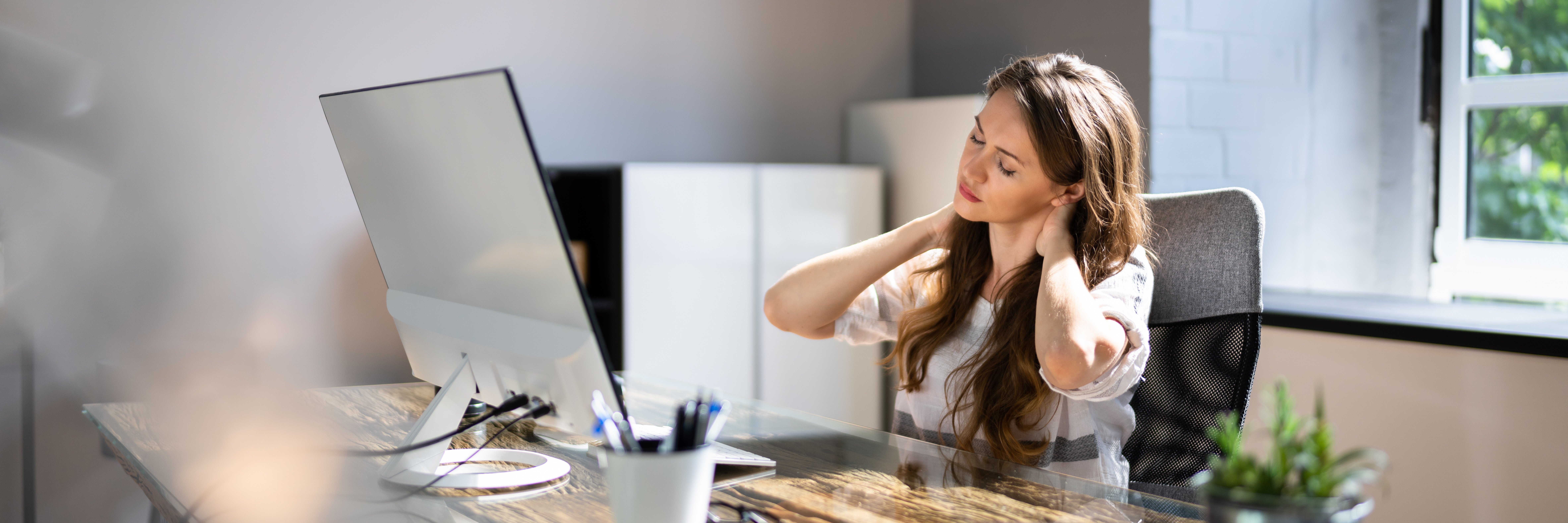 Woman sat at desk in pain