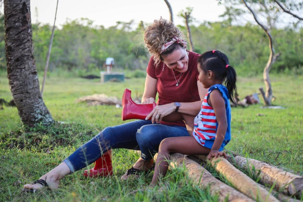 woman giving shoe to child